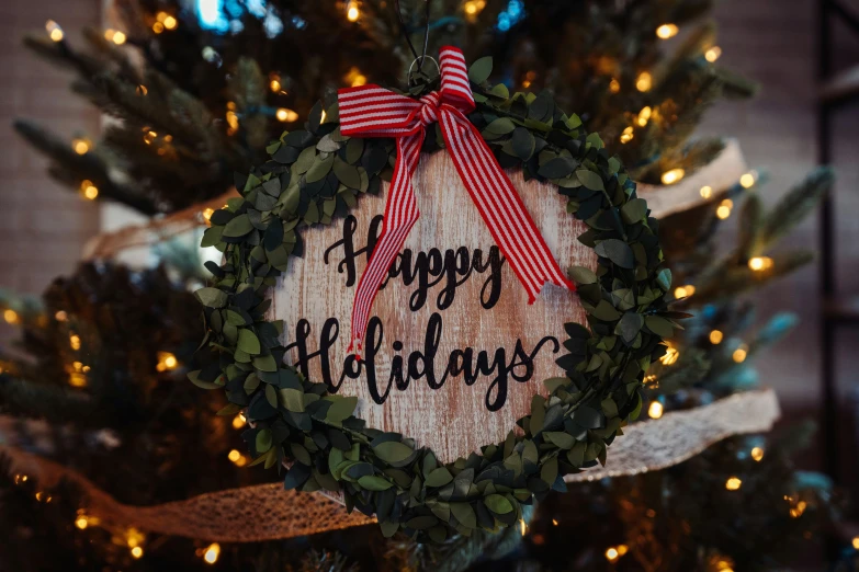 a holiday wreath with happy holidays written on it