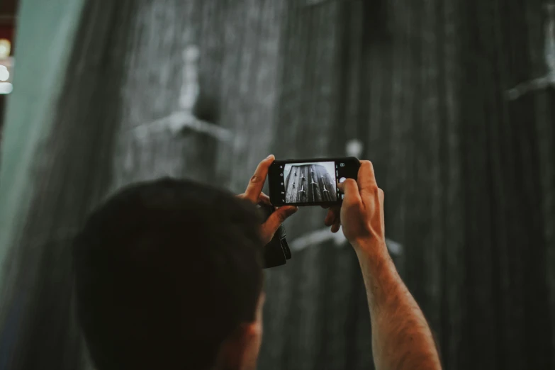 person taking a picture with his phone while standing up