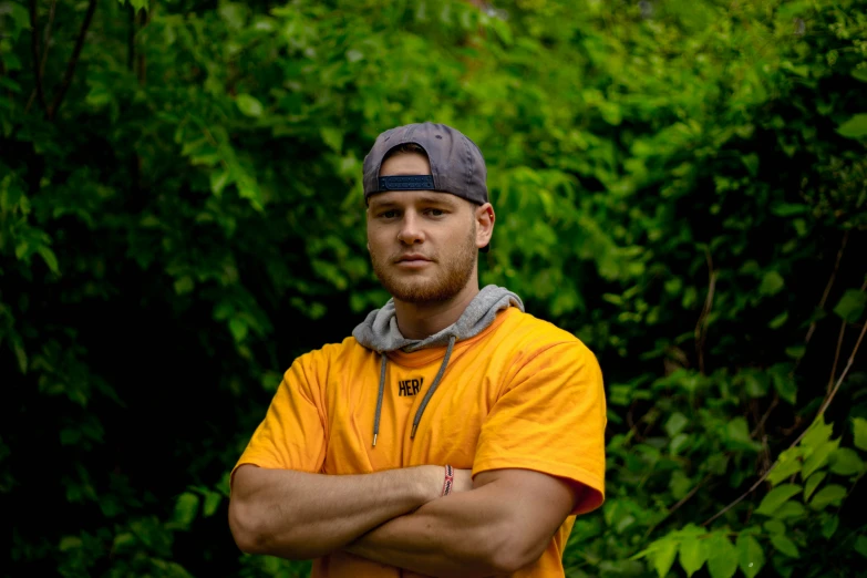 a young man is standing with his arms crossed