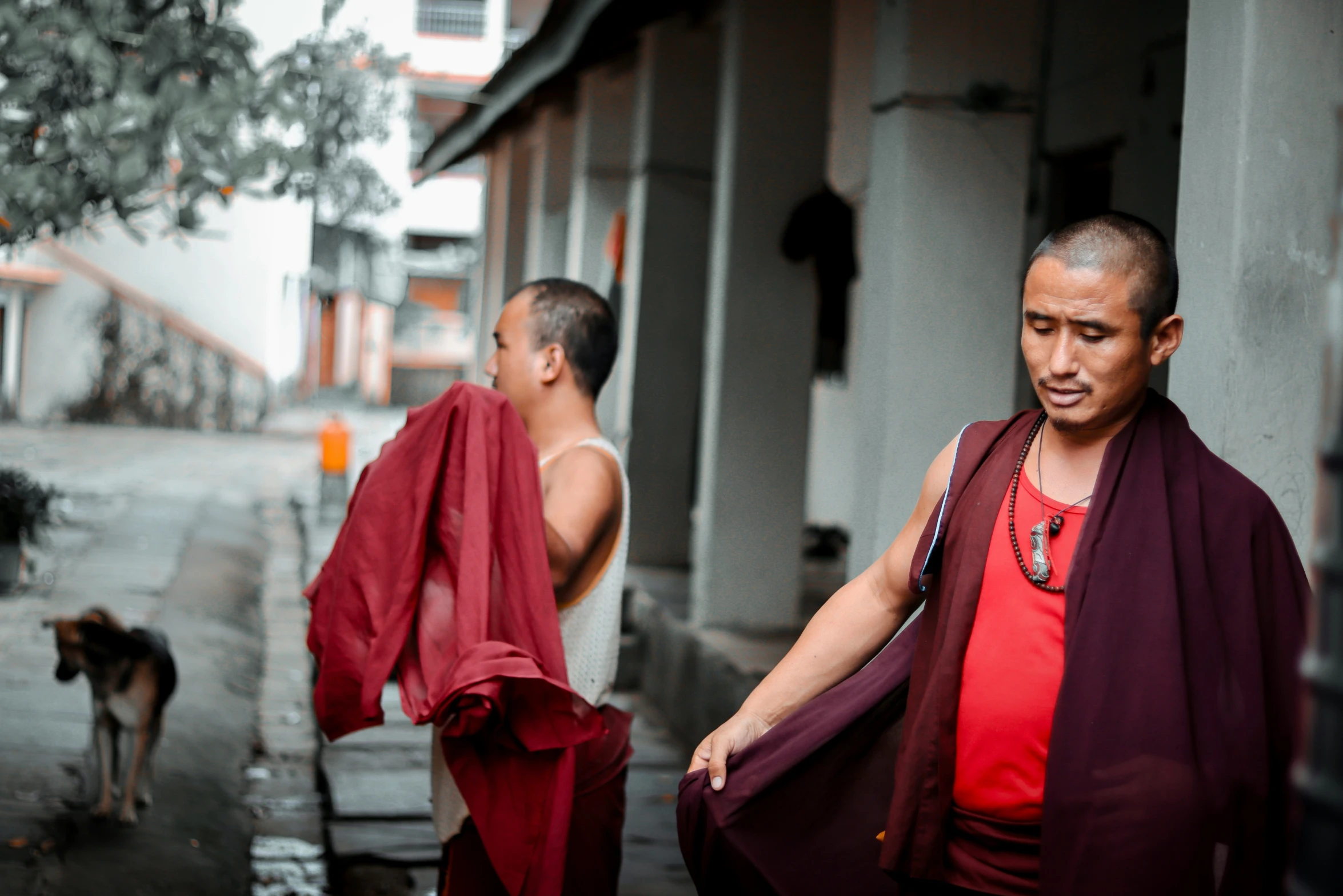 two men wearing robes standing next to a street