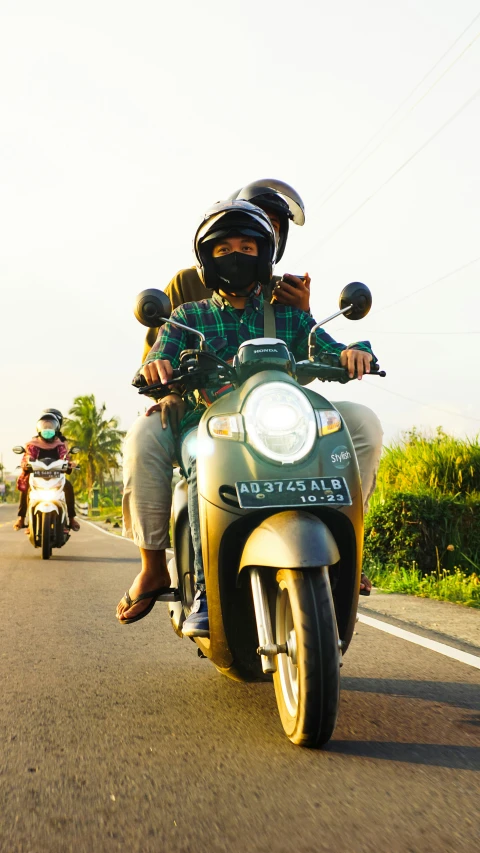 people riding motorcycles on the road on a sunny day