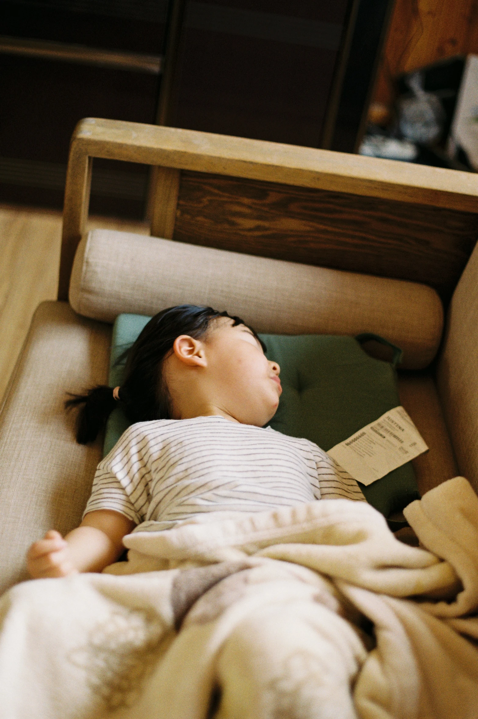 a toddler sleeping on top of a blanket in a child's crib