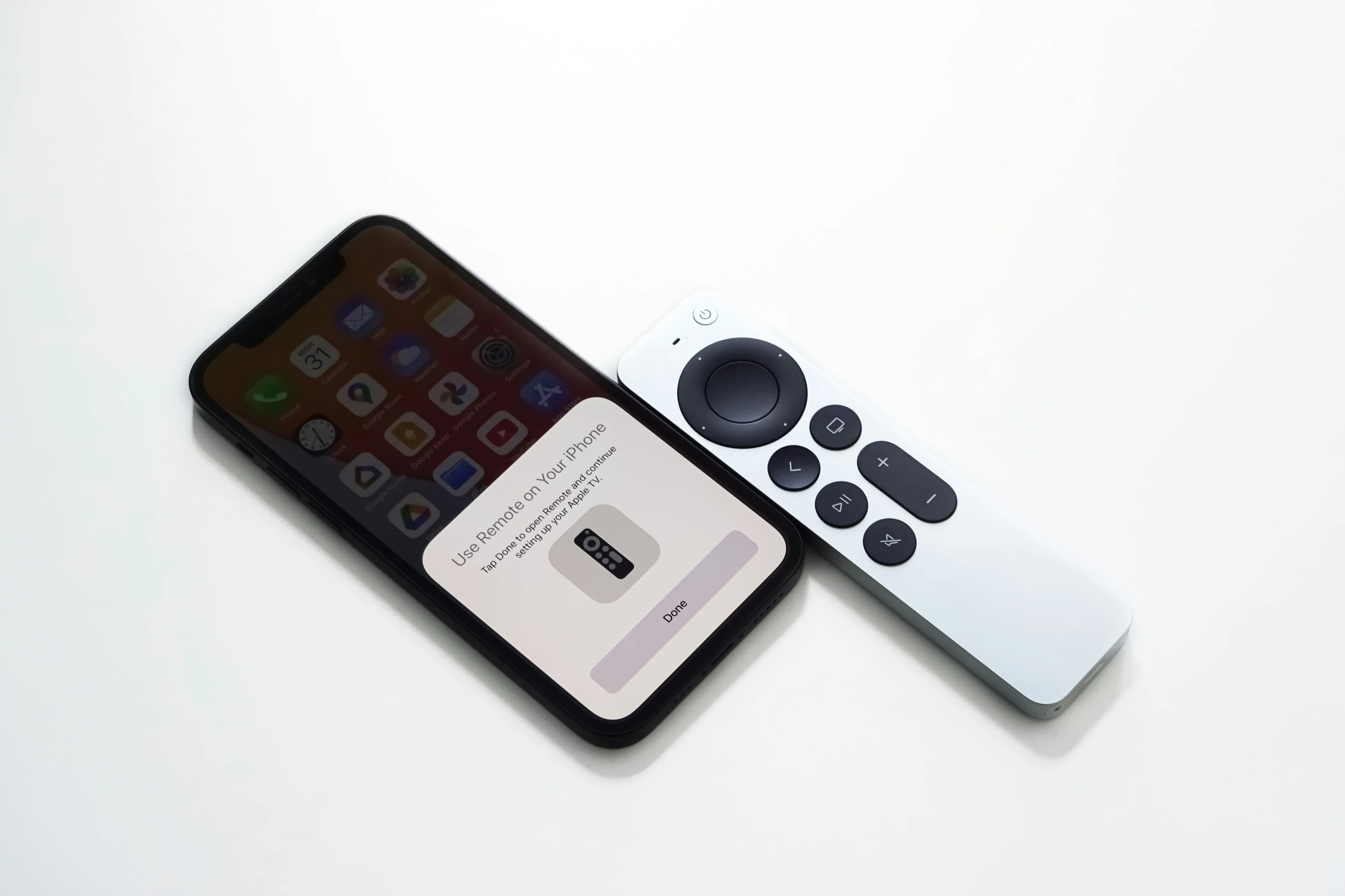 an iphone next to a white remote controller