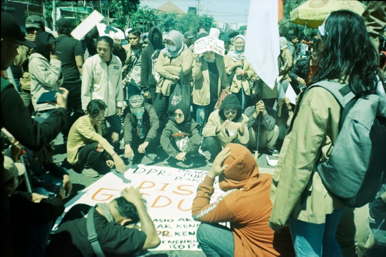 a group of people standing around holding signs