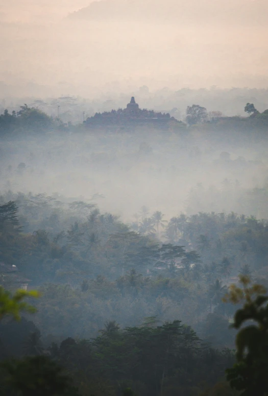 a hazy po with trees and foggy mountains