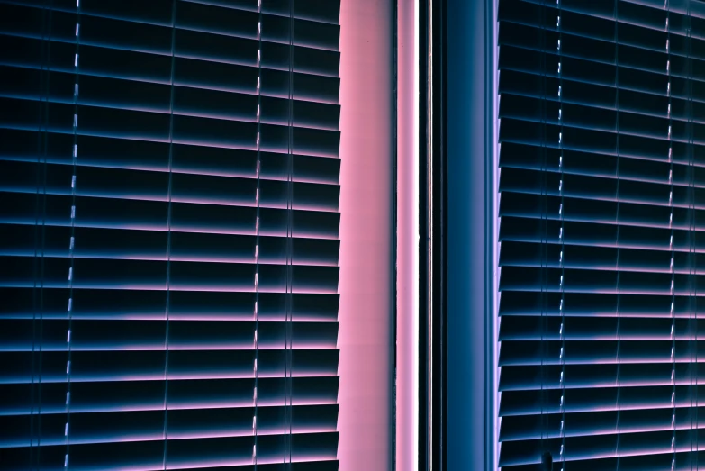 an open window with the blinds closed with only one light