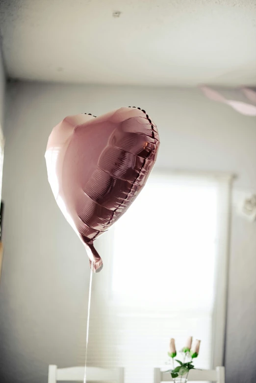 a balloon shaped like a heart hangs above a dining room table