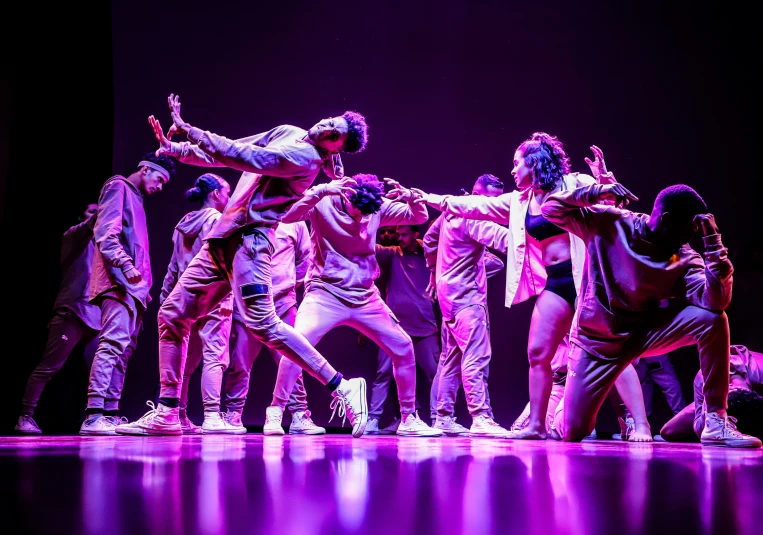 a group of dancers stand in a circle together