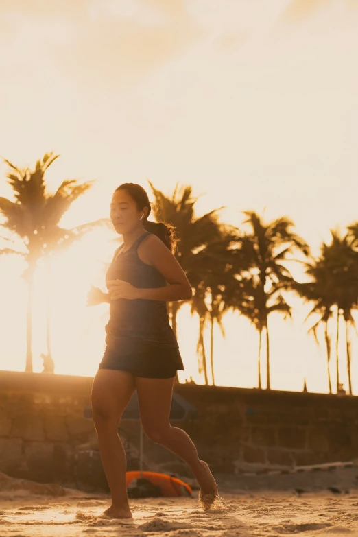 two people run on a beach near palm trees