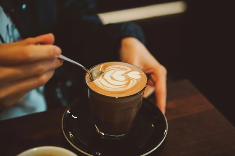 a cappuccino is being served in a cup with a spoon