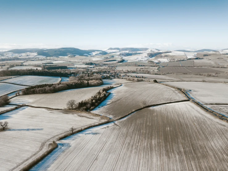 a snow covered countryside scene with a river running through it