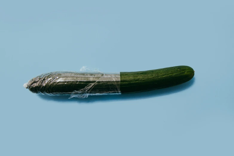 a very long cucumber is covered with plastic