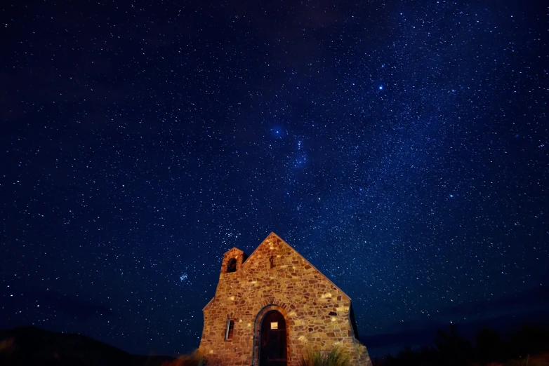 the stars are illuminated in the dark sky above an old church