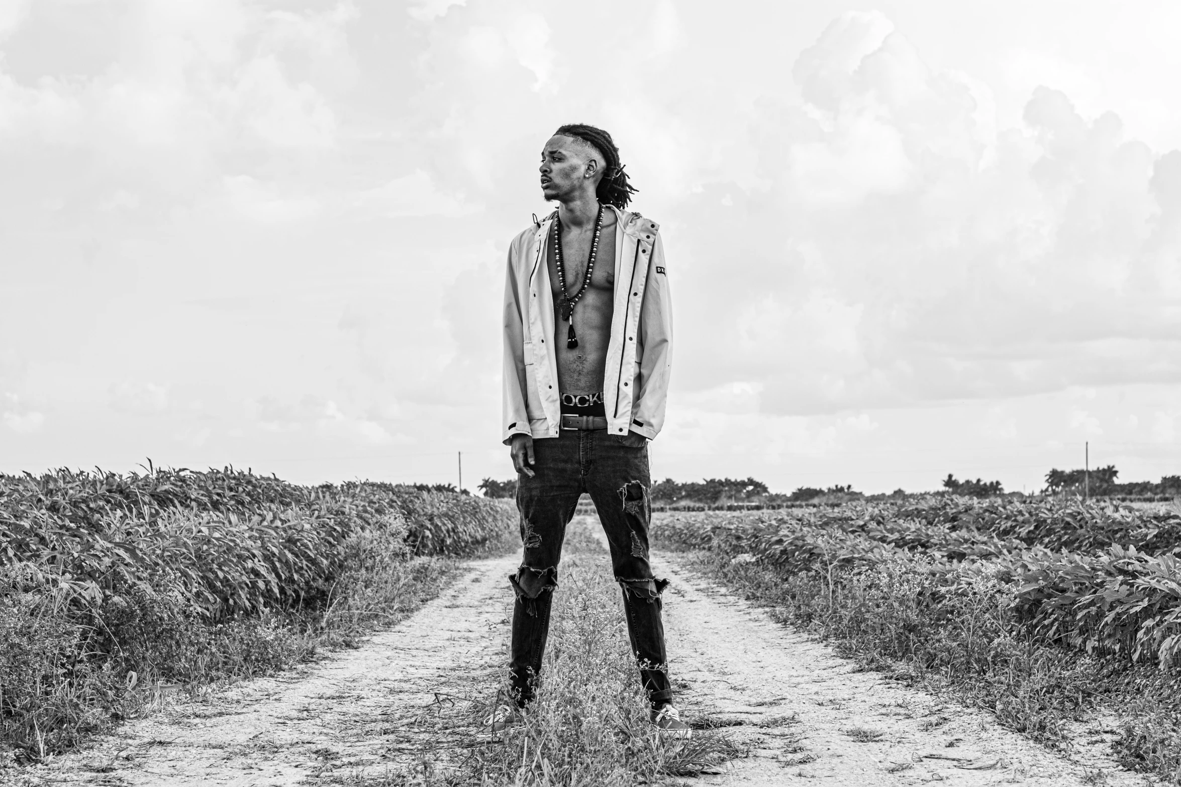 a young man standing on a dirt road