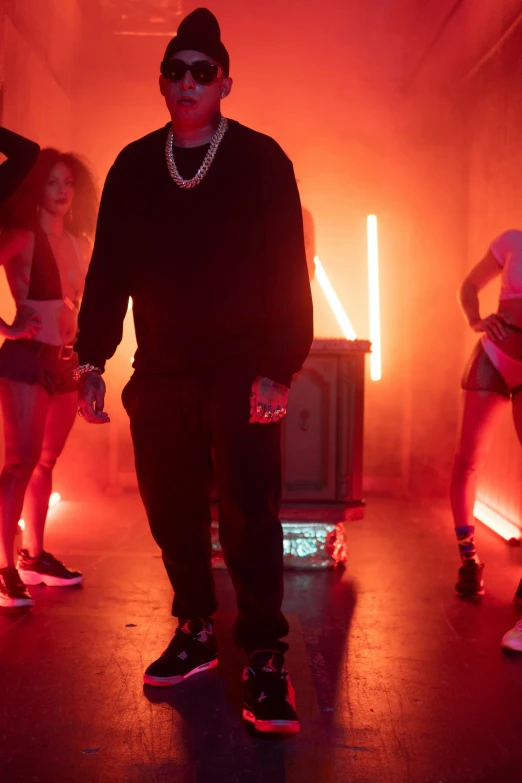 man with black hat and glasses standing near dancers