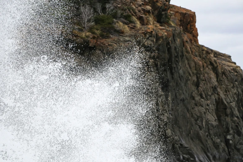 a very high wave hitting the rocks in front of it