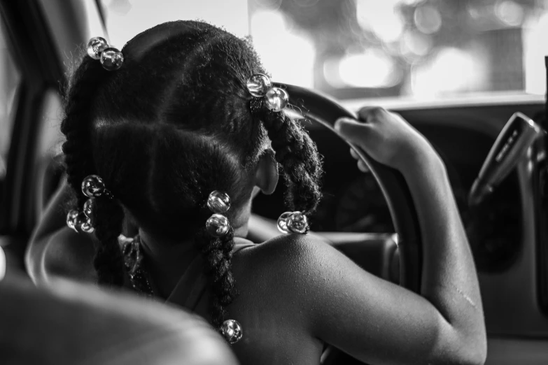 a woman is sitting in a car looking at her cell phone