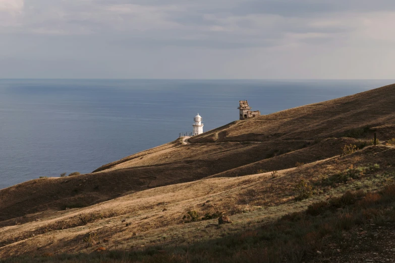 the lighthouse is visible above the large body of water