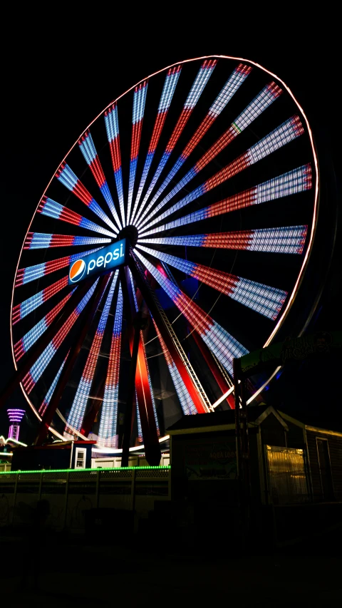 large wheel lit up at night and moving at various speeds