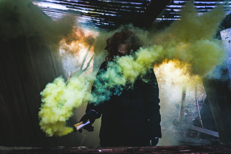 a woman is carrying smoke in the center of a room