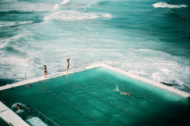 swimmers take in the ocean at a large pool