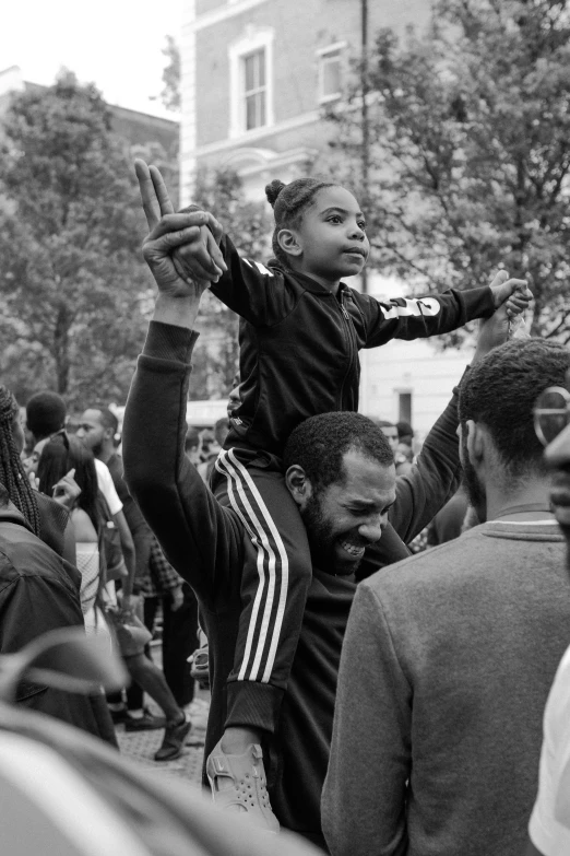 a small boy sitting on the shoulders of an adult