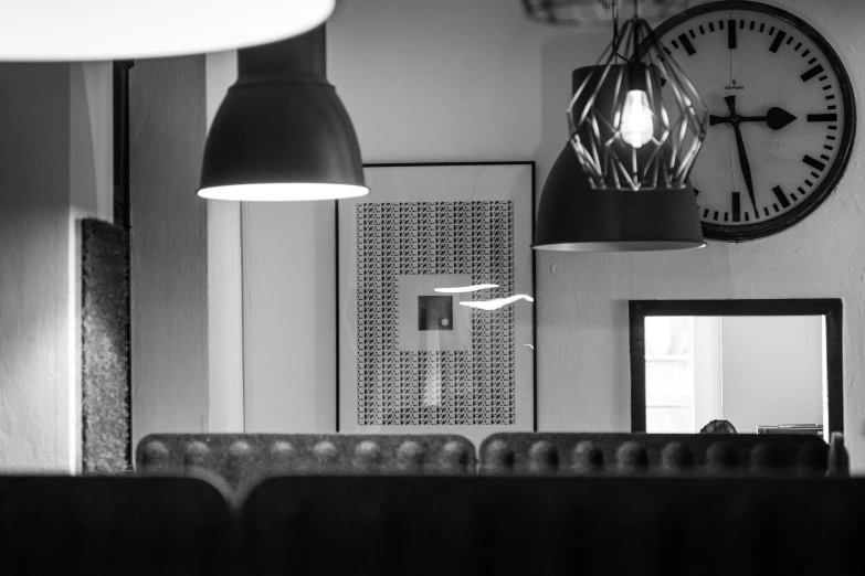 black and white pograph of a clock hanging in a room