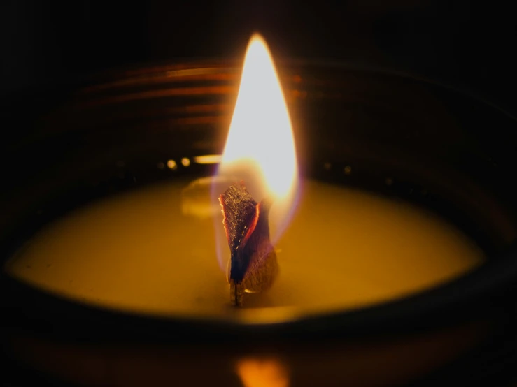 a candle burning inside of an oil container