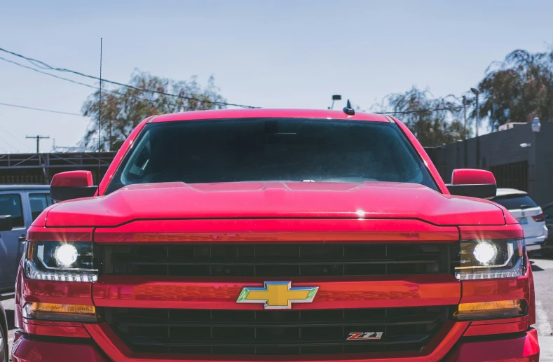 a red chevy truck parked in a lot