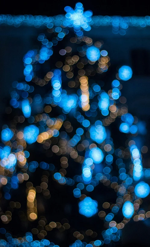 a light blue christmas tree at night