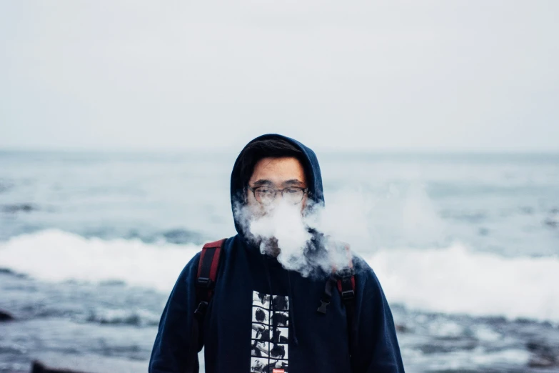 a person in a hoodie with smoke coming out of his face