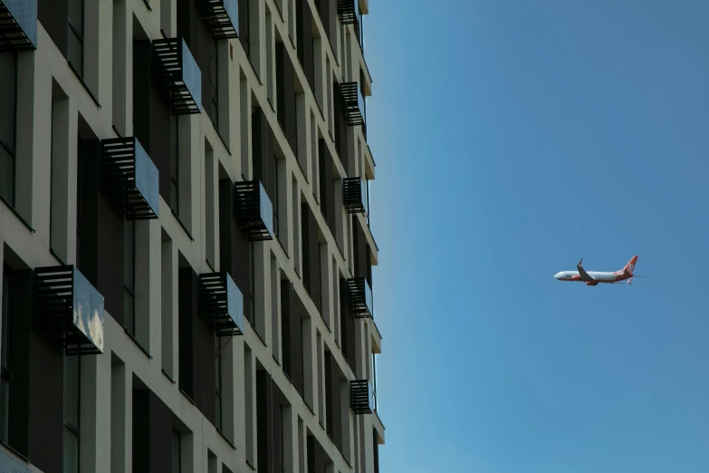 an airplane flying past a very tall building