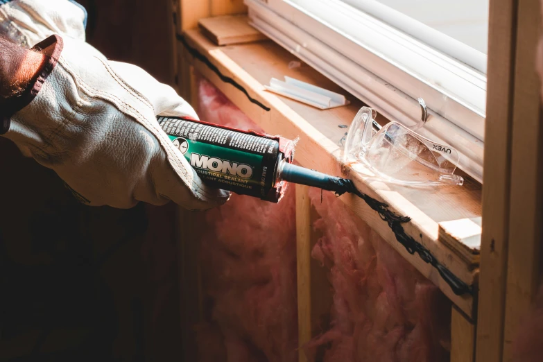 someone working on the side of a window with tools