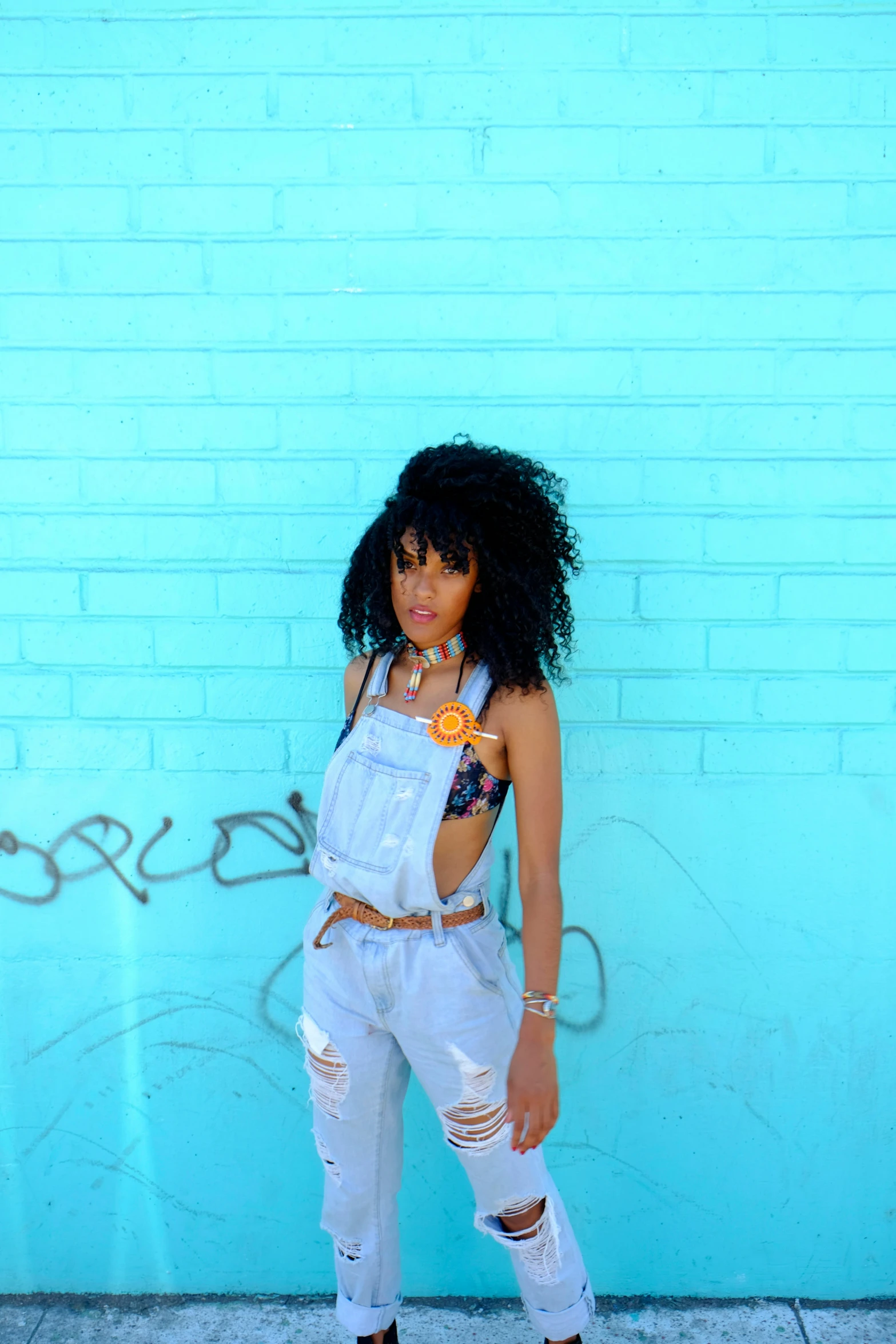 a woman in white clothes standing near a wall