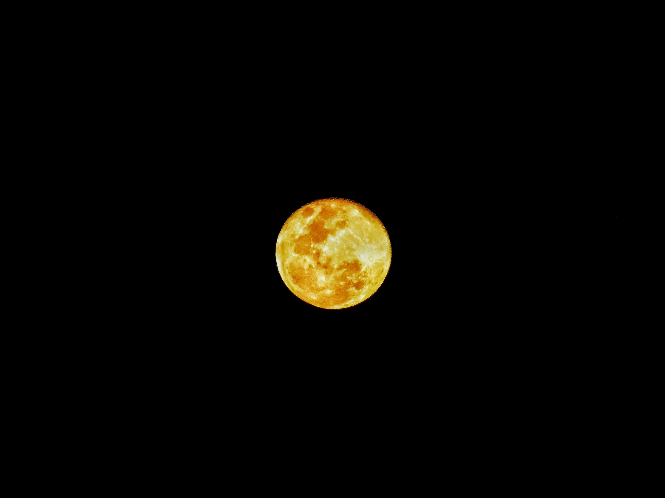 an orange moon against a black sky with no clouds