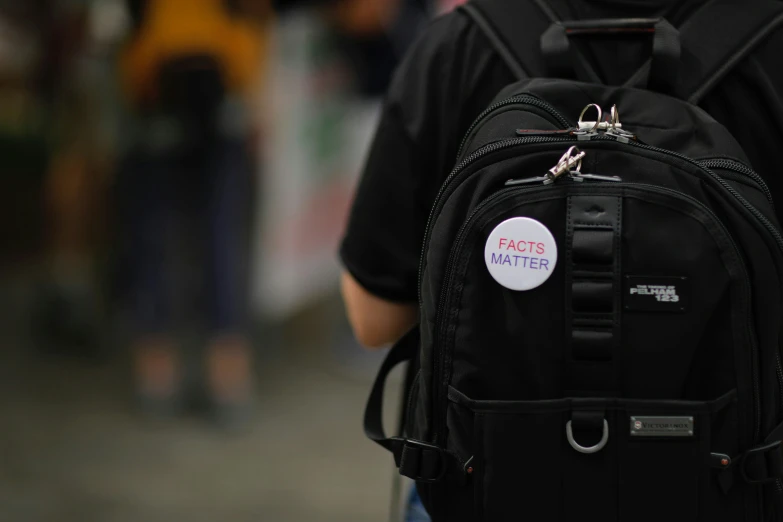 a close up of someone's black back pack with a sticker on the backpack