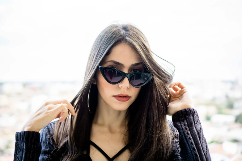 a woman with sunglasses on and wearing a black top