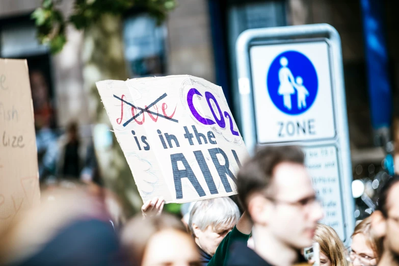 protestors holding signs in front of businesses during the day