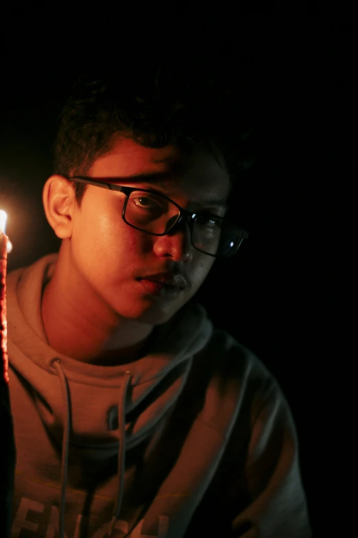 a man holding a lit candle in his hand