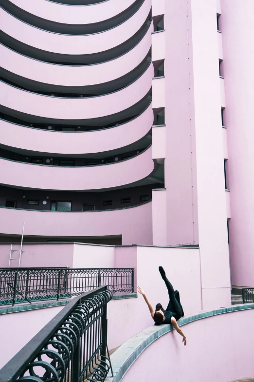 a man falling off a wall in front of some buildings