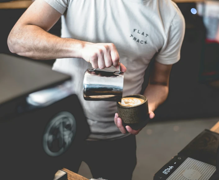 a man holding a coffee mug next to his laptop