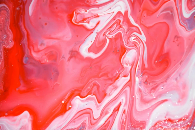 red, pink and blue acrylic fluid swirls on a surface