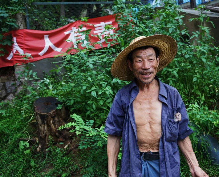 a shirtless man with a straw hat is posing