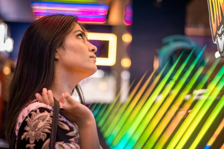 a woman looks up at an abstract piece of art