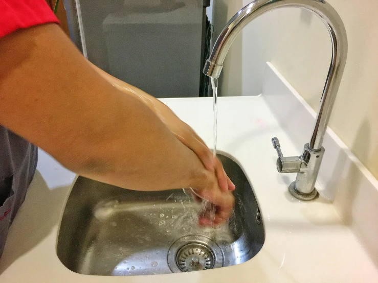 a person washing their hand in a sink