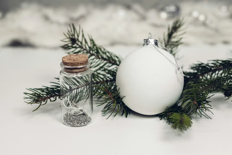 an egg sits in a glass bottle next to christmas ornaments