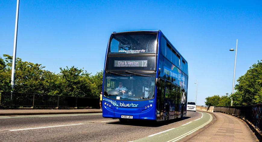 a double decker bus driving down a country road