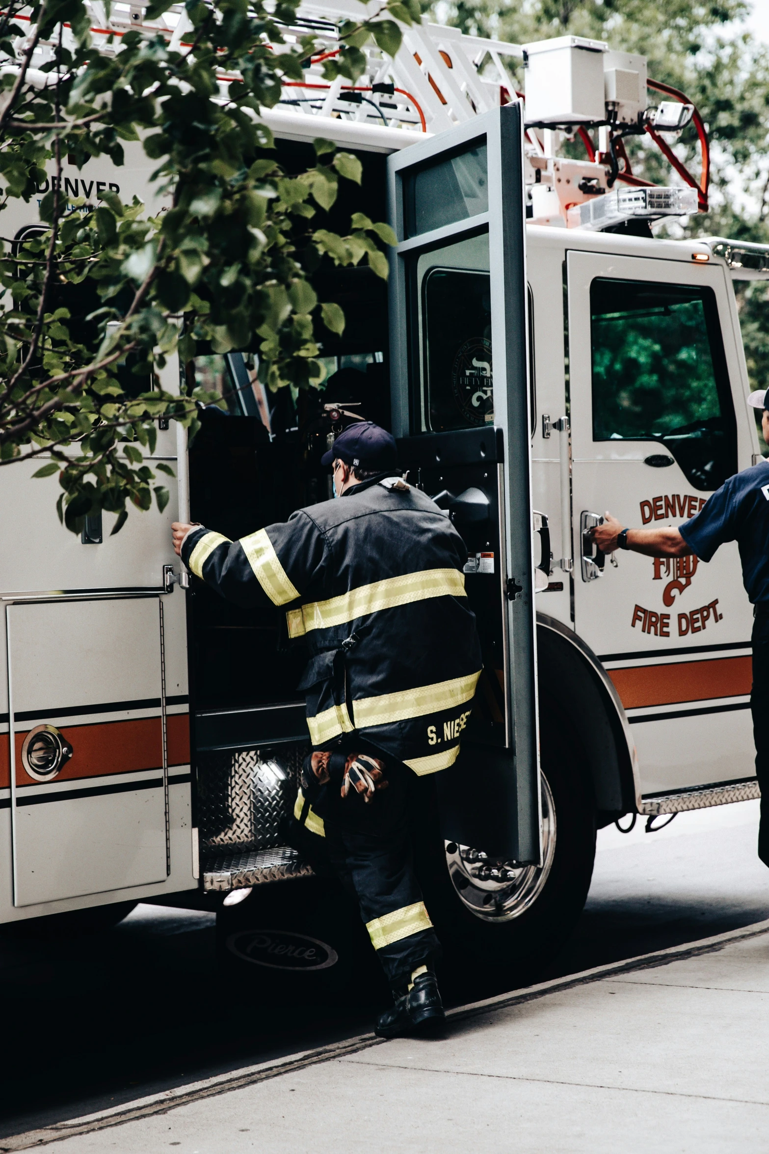 a man on the street helping another man climb into his truck