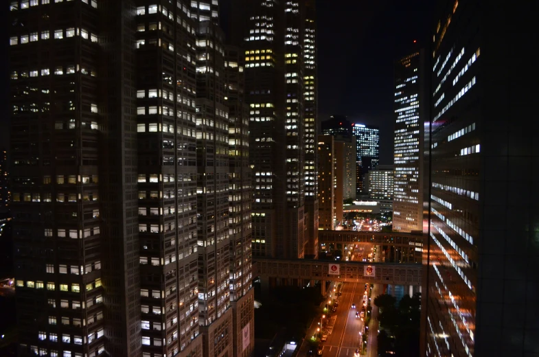 city buildings are lit up at night in a dark - colored scene