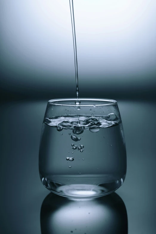 a glass filled with water with a straw sticking out of the top of it